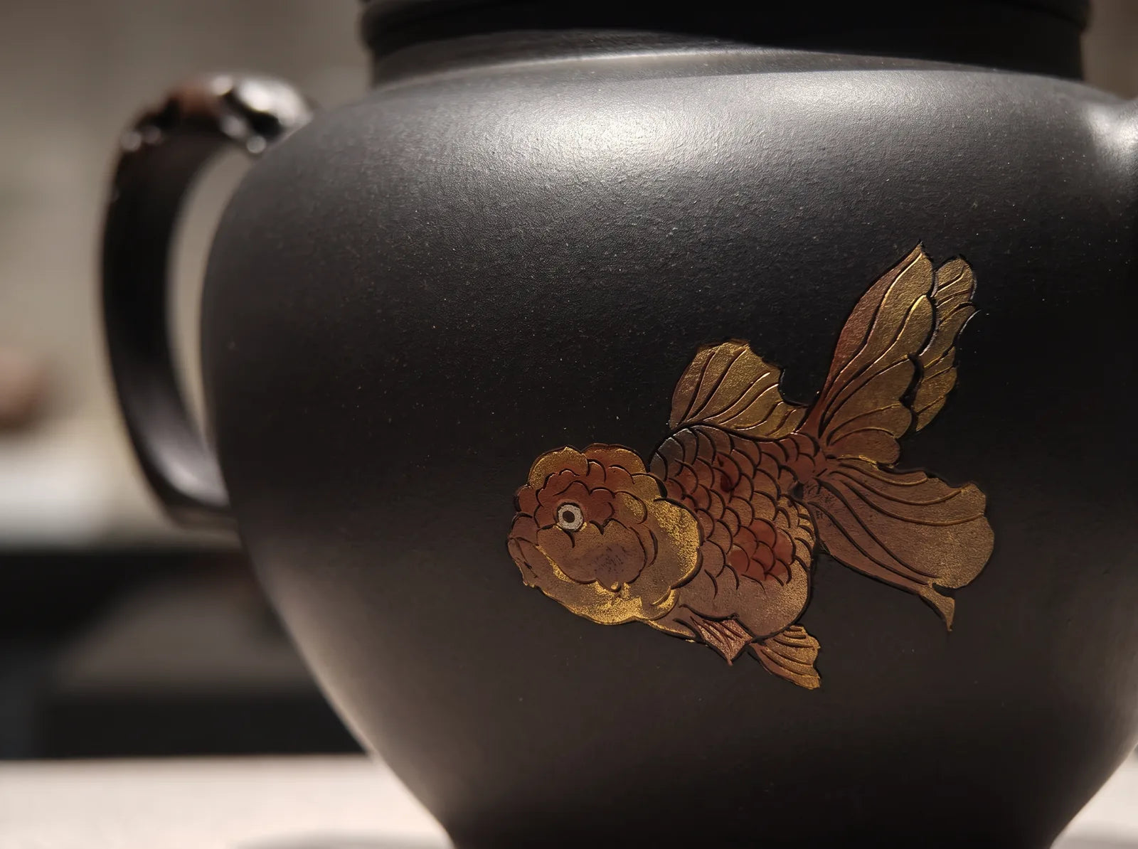 Black Duozhi Goldfish: goldfish motif moving across the dark unglazed clay