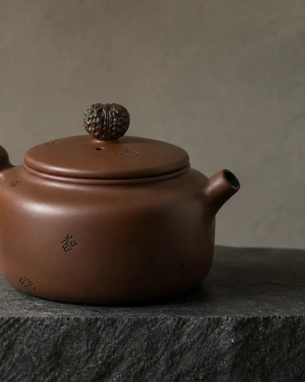 Hand-polished Jianshui purple pottery teapot on mineral stone