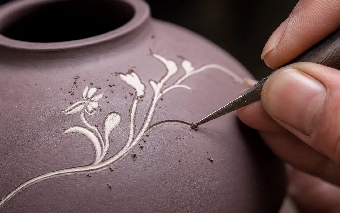 Artisan carving and filling a Jianshui pottery motif